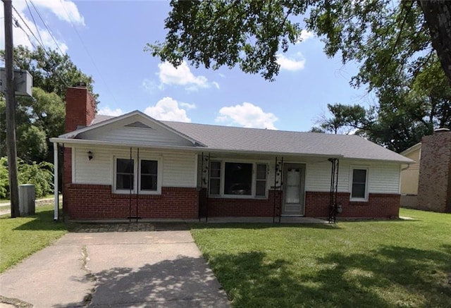 704 S Allen Ave, Chanute, KS 66720 - view of front of house featuring brick siding, a front lawn, and a chimney