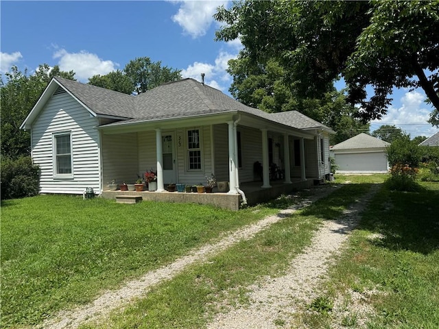 515 W 7th Ave, Garnett, KS 66032 - view of front of home featuring covered porch, a front yard, roof with shingles, and a garage