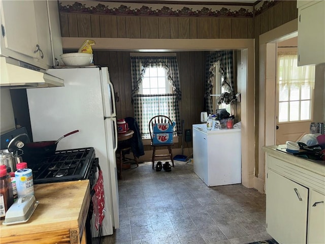 515 W 7th Ave, Garnett, KS 66032 - kitchen with under cabinet range hood, washer / clothes dryer, range with gas cooktop, and white cabinets