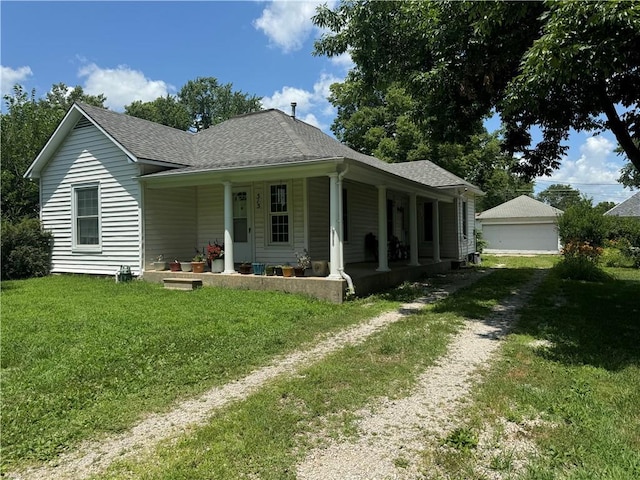 515 W 7th Ave, Garnett, KS 66032 - view of front facade with covered porch, a front lawn, roof with shingles, and a garage