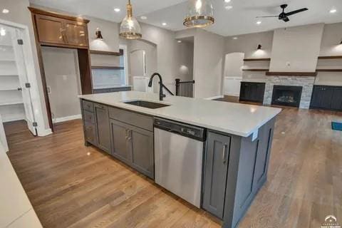 25446 W 91st Ter, Lenexa, KS 66227 - kitchen featuring stainless steel dishwasher, light wood-type flooring, a ceiling fan, light countertops, and a kitchen island with sink
