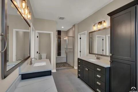 25446 W 91st Ter, Lenexa, KS 66227 - full bathroom featuring two vanities and a stall shower