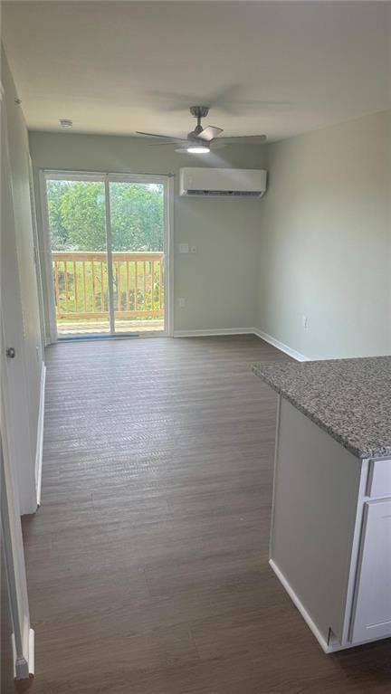1106 S Mitchell St, Warrensburg, MO 64093 - unfurnished room with a wall mounted AC, dark wood finished floors, and a ceiling fan