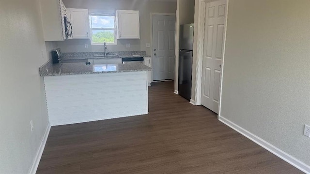 1106 S Mitchell St, Warrensburg, MO 64093 - kitchen featuring appliances with stainless steel finishes, white cabinetry, dark wood-type flooring, a peninsula, and light stone counters