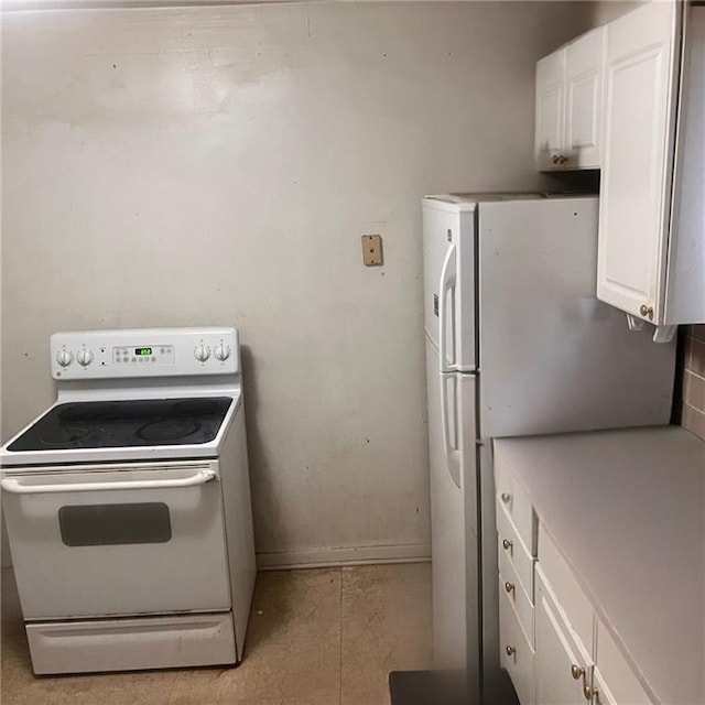 2125 N 45th St, Kansas City, KS 66104 - kitchen with white appliances, white cabinets, light tile patterned floors, and light countertops