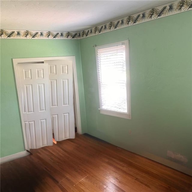 2125 N 45th St, Kansas City, KS 66104 - unfurnished bedroom with hardwood / wood-style flooring and a closet