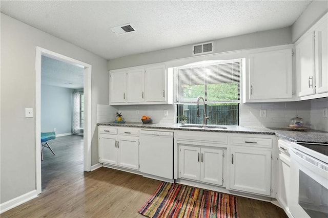 12704 W 110th Ter, Overland Park, KS 66210 - kitchen featuring white appliances, white cabinetry, wood finished floors, decorative backsplash, and a textured ceiling