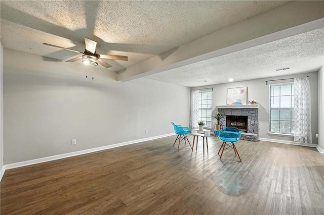 12704 W 110th Ter, Overland Park, KS 66210 - unfurnished room featuring a textured ceiling, wood finished floors, a fireplace, and ceiling fan