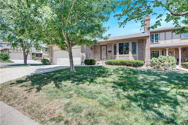 11016 W 96th Ter, Overland Park, KS 66214 - view of front of house with an attached garage, driveway, a front yard, a chimney, and brick siding