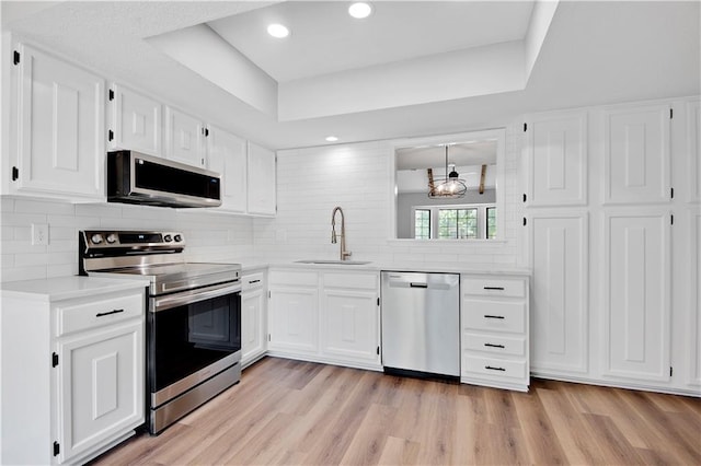 11016 W 96th Ter, Overland Park, KS 66214 - kitchen featuring appliances with stainless steel finishes, light countertops, backsplash, white cabinetry, and recessed lighting