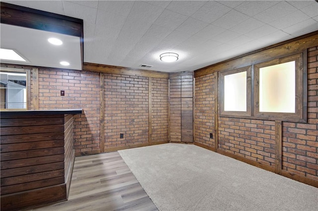 11016 W 96th Ter, Overland Park, KS 66214 - below grade area featuring brick wall and wood finished floors