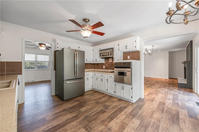 38 Hillcrest Dr, Platte City, MO 64079 - kitchen with stainless steel appliances, a chandelier, a ceiling fan, dark wood-style flooring, and crown molding