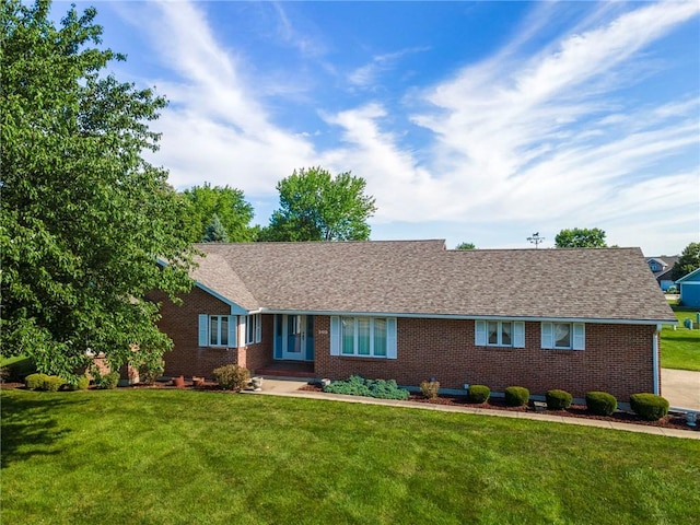 205 E 10th St, Carrollton, MO 64633 - ranch-style home with brick siding, a front yard, and a shingled roof