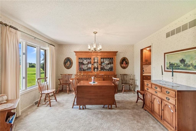 205 E 10th St, Carrollton, MO 64633 - dining room featuring wallpapered walls, a chandelier, a textured ceiling, and light carpet