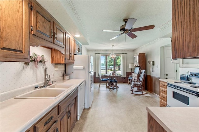 205 E 10th St, Carrollton, MO 64633 - kitchen featuring white appliances, light floors, light countertops, ceiling fan, and brown cabinets