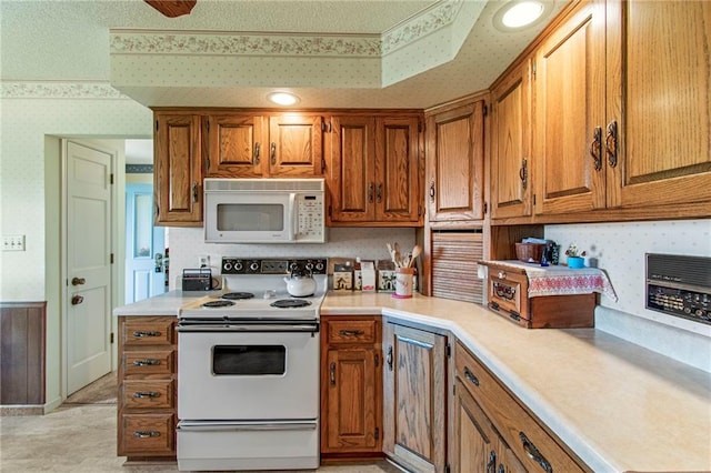 205 E 10th St, Carrollton, MO 64633 - kitchen featuring white appliances, wallpapered walls, and brown cabinetry