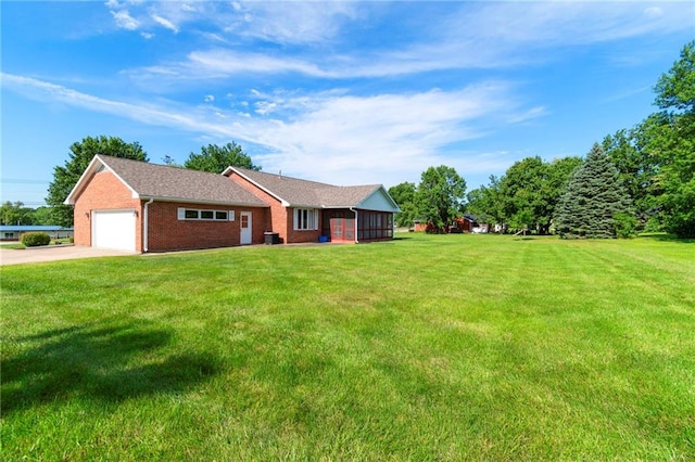 205 E 10th St, Carrollton, MO 64633 - view of front of home with brick siding, a front yard, driveway, a garage, and a sunroom