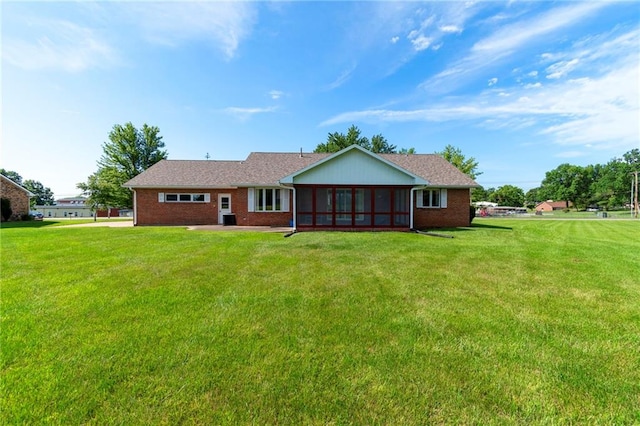 205 E 10th St, Carrollton, MO 64633 - rear view of property with a lawn, a sunroom, and brick siding