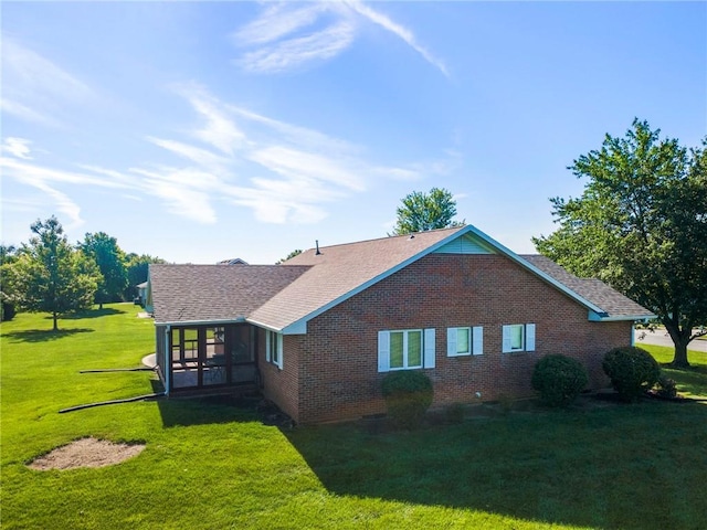 205 E 10th St, Carrollton, MO 64633 - view of property exterior with brick siding, a yard, roof with shingles, and a sunroom