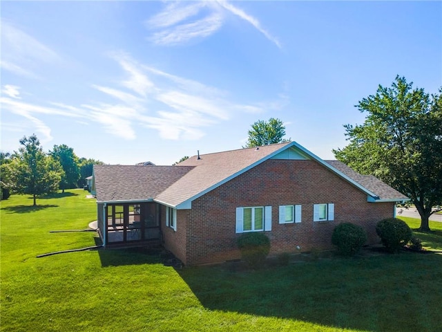 205 E 10th St, Carrollton, MO 64633 - view of side of property featuring brick siding, a lawn, and a shingled roof