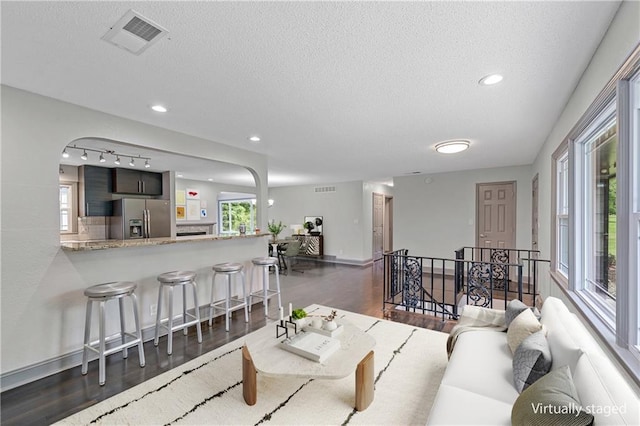 2517 Red Bridge Ter, Kansas City, MO 64131 - living room featuring wood finished floors, a textured ceiling, track lighting, and recessed lighting