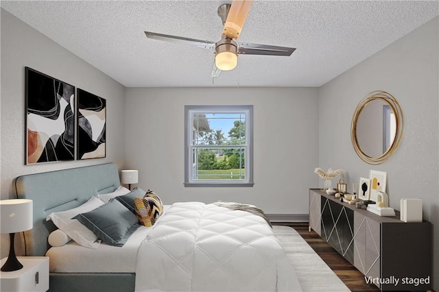 2517 Red Bridge Ter, Kansas City, MO 64131 - bedroom featuring dark wood-style flooring, a textured ceiling, and ceiling fan