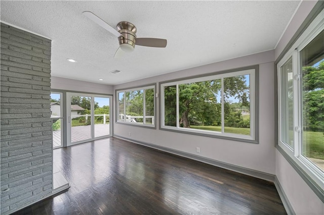 2517 Red Bridge Ter, Kansas City, MO 64131 - unfurnished sunroom featuring plenty of natural light, a textured ceiling, and wood finished floors