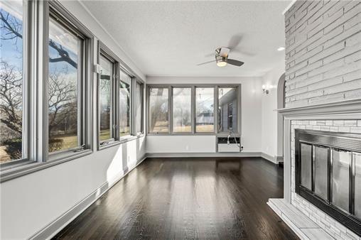2517 Red Bridge Ter, Kansas City, MO 64131 - unfurnished sunroom with wood finished floors and baseboards