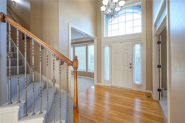12337 Gillette St, Overland Park, KS 66213 - foyer featuring light wood-type flooring, a chandelier, stairs, and a towering ceiling