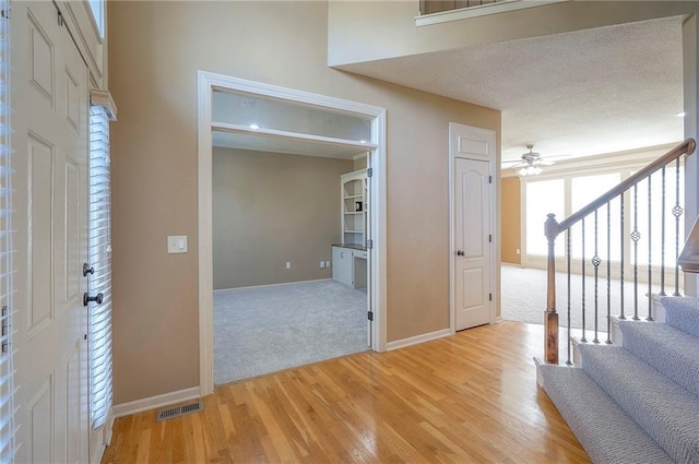 12337 Gillette St, Overland Park, KS 66213 - foyer with stairs, a ceiling fan, light wood-style flooring, and light carpet