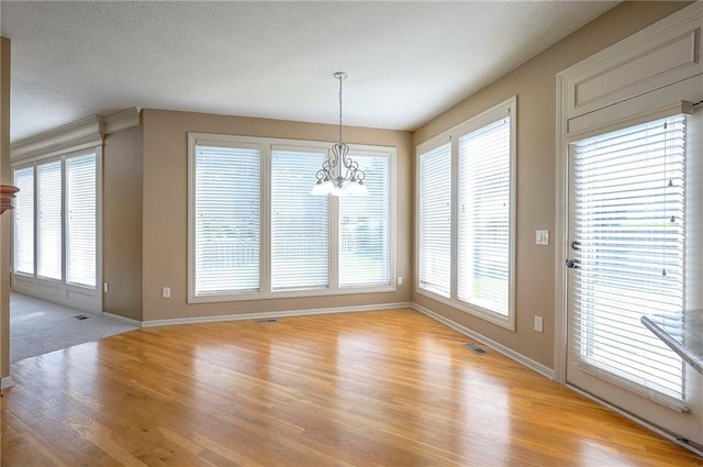 12337 Gillette St, Overland Park, KS 66213 - unfurnished dining area with light wood-style floors, a chandelier, and plenty of natural light