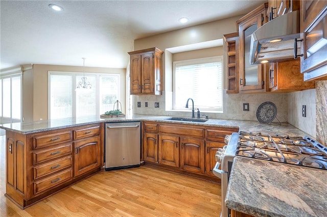12337 Gillette St, Overland Park, KS 66213 - kitchen featuring stainless steel appliances, a peninsula, brown cabinets, exhaust hood, and recessed lighting