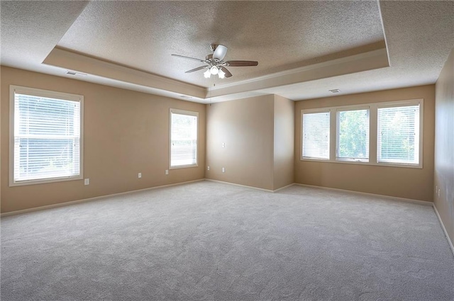 12337 Gillette St, Overland Park, KS 66213 - empty room featuring a tray ceiling, a textured ceiling, ceiling fan, and light carpet