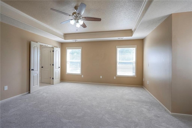 12337 Gillette St, Overland Park, KS 66213 - carpeted empty room featuring a textured ceiling, a tray ceiling, healthy amount of natural light, ceiling fan, and ornamental molding