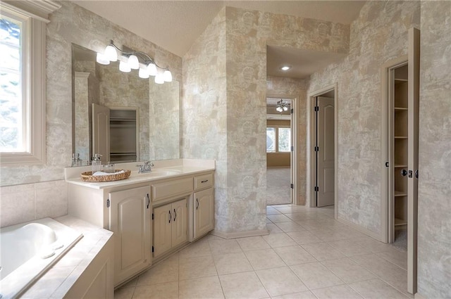 12337 Gillette St, Overland Park, KS 66213 - bathroom with vanity, tile patterned floors, a garden tub, and a walk in closet