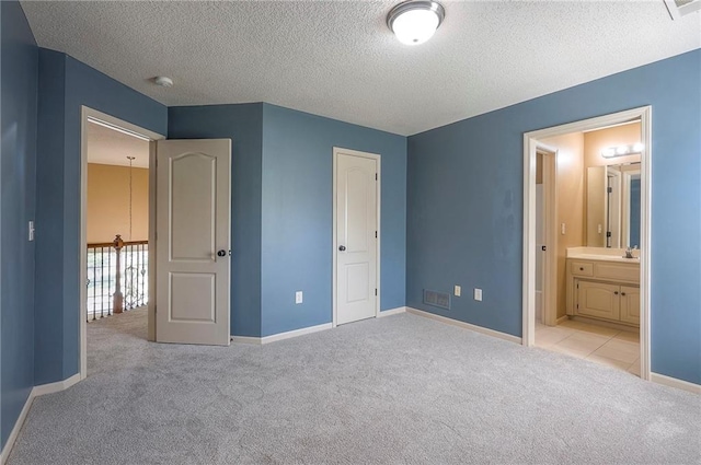 12337 Gillette St, Overland Park, KS 66213 - unfurnished bedroom with light carpet, a textured ceiling, and connected bathroom