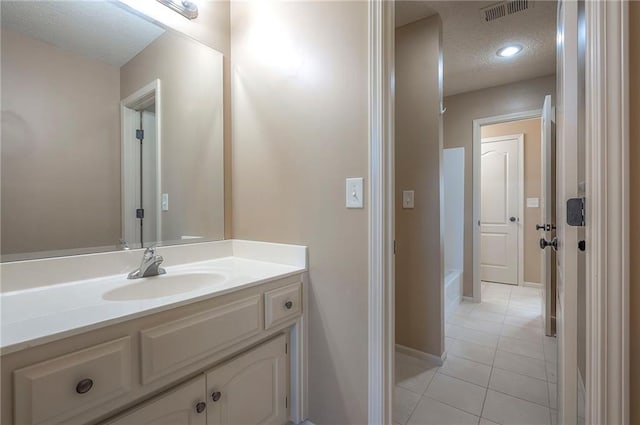 12337 Gillette St, Overland Park, KS 66213 - full bath featuring a textured ceiling, vanity, tile patterned floors, and a bathtub