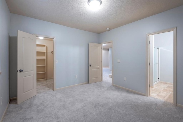 12337 Gillette St, Overland Park, KS 66213 - unfurnished bedroom with a walk in closet, carpet flooring, and a textured ceiling