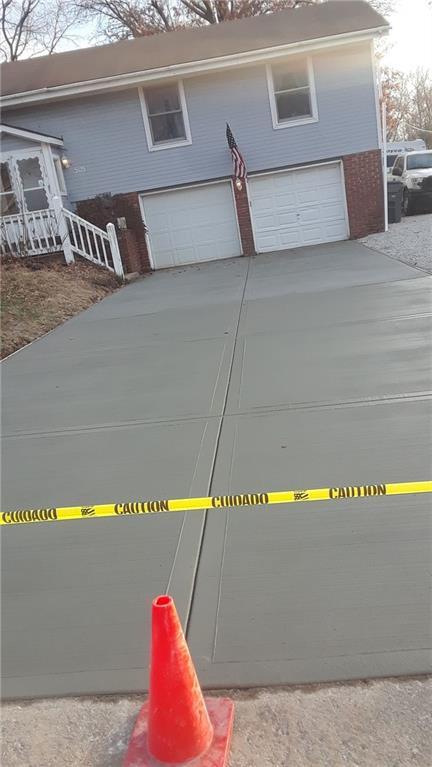 505 E Harold St, Olathe, KS 66061 - view of front facade featuring an attached garage, concrete driveway, and brick siding