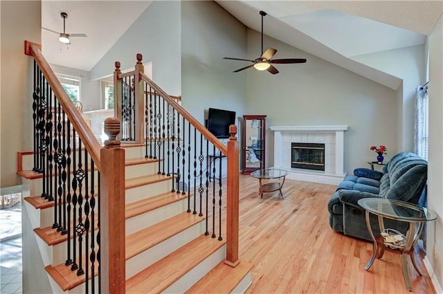 6236 W 156th St, Overland Park, KS 66223 - stairway featuring wood finished floors, a ceiling fan, a fireplace, and high vaulted ceiling