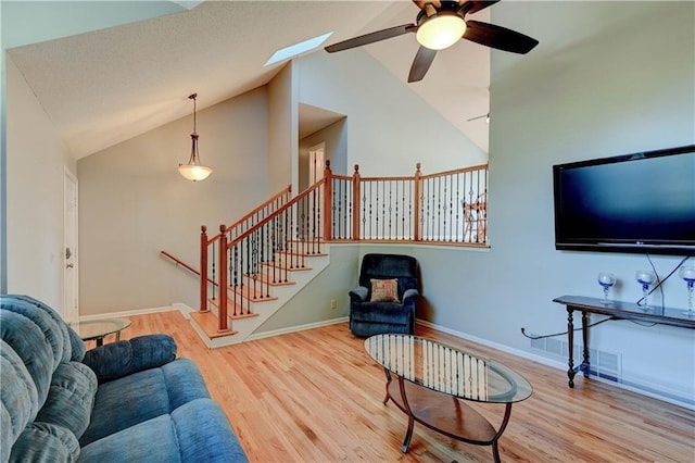 6236 W 156th St, Overland Park, KS 66223 - living area with a ceiling fan, wood finished floors, a skylight, high vaulted ceiling, and stairs