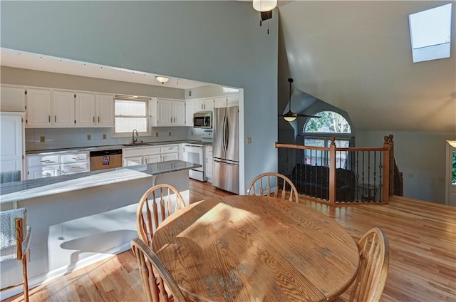 6236 W 156th St, Overland Park, KS 66223 - dining area featuring ceiling fan, light wood-style flooring, and high vaulted ceiling
