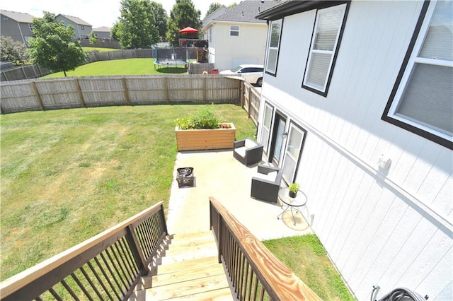 1207 SW 9th St, Oak Grove, MO 64075 - fenced backyard with a trampoline and a patio