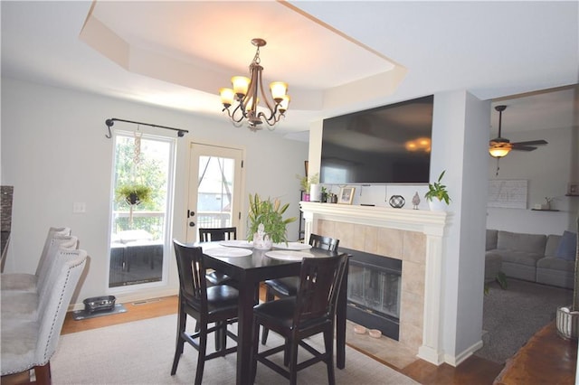 1207 SW 9th St, Oak Grove, MO 64075 - dining space with a tray ceiling, a chandelier, a fireplace, and a ceiling fan