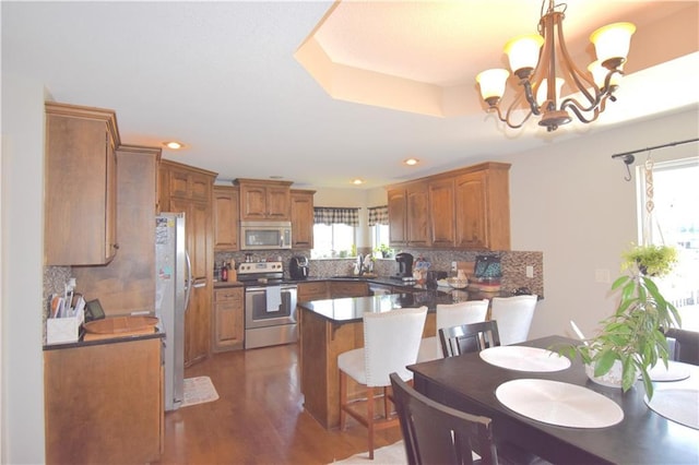 1207 SW 9th St, Oak Grove, MO 64075 - kitchen featuring appliances with stainless steel finishes, a chandelier, tasteful backsplash, wood finished floors, and recessed lighting