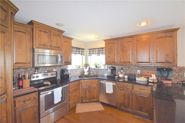 1207 SW 9th St, Oak Grove, MO 64075 - kitchen with appliances with stainless steel finishes, wood finished floors, tasteful backsplash, brown cabinets, and recessed lighting