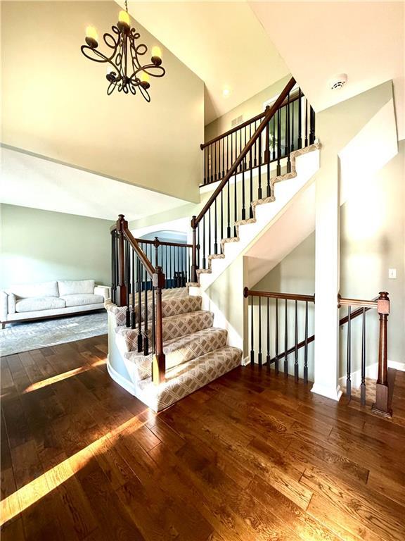 4531 Anderson St, Shawnee, KS 66226 - stairway featuring hardwood / wood-style flooring and a chandelier