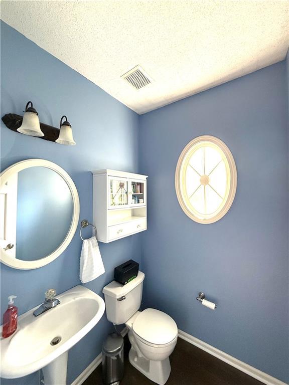 4531 Anderson St, Shawnee, KS 66226 - half bathroom with a textured ceiling and wood finished floors