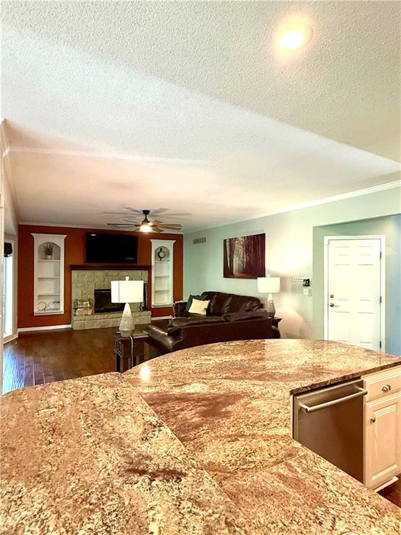 4531 Anderson St, Shawnee, KS 66226 - kitchen featuring dark wood-style floors, a textured ceiling, open floor plan, light stone counters, and ceiling fan