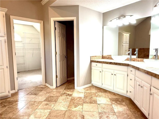 4531 Anderson St, Shawnee, KS 66226 - bathroom featuring vanity, a spacious closet, and a textured ceiling